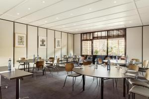 a dining room with tables and chairs and windows at Radisson Blu 1882 Hotel, Barcelona Sagrada Familia in Barcelona +162 photos