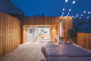 a patio with a table and chairs on a wooden deck at 한 스위트 서울 in Seoul