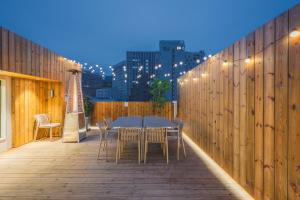 a table and chairs on a wooden deck with lights at 한 스위트 서울 in Seoul