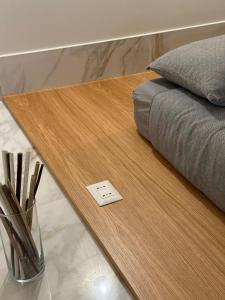 Ein Holztisch mit einem Thermometer darauf neben einem Bett in der Unterkunft Avril Suite in Noci