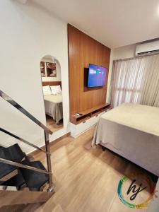 a hotel room with a bed and a flat screen tv at Mares Cabo Branco 507 in Tambaú