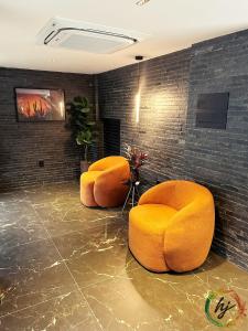 two orange chairs in a room with a wall at Mares Cabo Branco 507 in Tambaú
