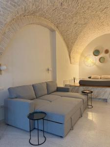 ein Wohnzimmer mit Sofa und Bett in der Unterkunft Avril Suite in Noci