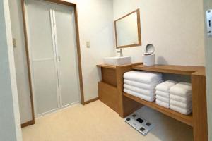 a bathroom with a sink and a mirror and towels at 白樺 l リノベーション済 l 千歳空港まで30分 l 貸切の一軒家 l 8名様までOK in Yuni +33 photos