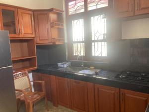 a kitchen with wooden cabinets and a sink and a stove at Siva Residencies in Wattala