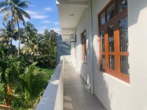 a hallway of a house with palm trees in the background at Siva Residencies in Wattala