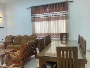 a dining room with a table and chairs and a couch at Siva Residencies in Wattala