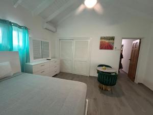 a bedroom with a bed and a table in it at Blue Sail Rooms in Koolbaai