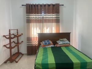 a bedroom with a bed with a green and yellow blanket at Siva Residencies in Wattala +20 photos