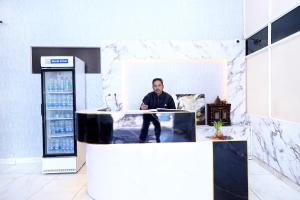 a man sitting at a counter in a gas station at Hotel S2 Residency Near Railway Station Chandigarh in Chandīgarh