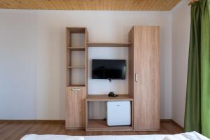 a room with a tv and a book shelf at Villa Panoramic Sovata in Sovata