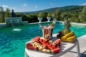 a tray of fruit on a table next to a swimming pool at Villa Panoramic Sovata in Sovata