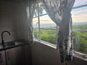 a window in a bathroom with a sink and a curtain at Nguni Rest in Barberton +54 photos