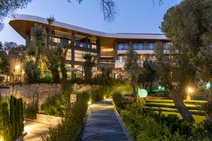 an external view of a building with a garden at night at Unique Life Style Hotel in Kuşadası