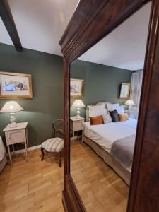 a bedroom with a large bed and a mirror at Coté Cour Bischwihr Colmar 2 in Bischwihr