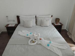 a white bed with two towels on it at La Residence D'Almée Apartment and Studio in Praslin