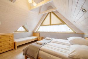 a bedroom with a large bed in a attic at Domki Trzy Korony in Sromowce Niżne