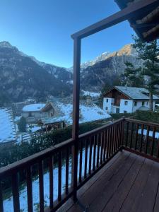 a view from the deck of a house with snow covered mountains at L'Atelier du Temps - Chalet Crammont in Courmayeur