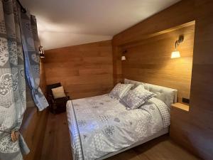 a bedroom with a bed and a wooden wall at L'Atelier du Temps - Chalet Crammont in Courmayeur