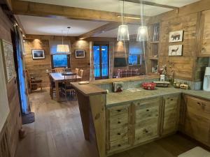 a large kitchen with wooden walls and a dining room at L'Atelier du Temps - Chalet Crammont in Courmayeur