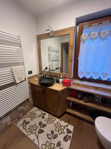 a bathroom with a sink and a large mirror at L'Atelier du Temps - Chalet Crammont in Courmayeur