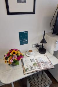 a desk with a book and a vase of flowers at La Paz Apart Hotel in Lima