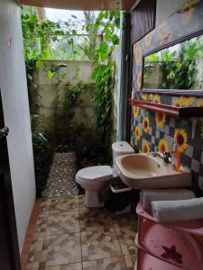 a bathroom with a toilet and a sink at Casa Sol in Sarapiquí +25 photos