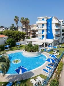 a pool with chairs and umbrellas in front of a hotel at Hotel Jerry - Beachfront & Private Pool in Grottammare