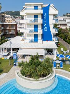 a hotel with a swimming pool in front of a building at Hotel Jerry - Beachfront & Private Pool in Grottammare