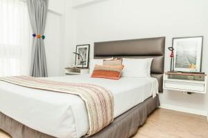 a bedroom with a large white bed and a window at La Paz Apart Hotel in Lima