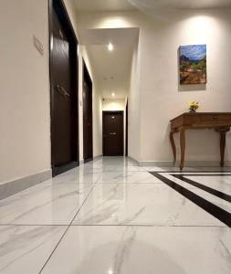 ein leerer Flur mit einem Tisch und einer Tür in der Unterkunft Sama AL Hamra Hotel Apartments in Raʼs Bayrūt