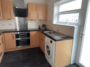 a kitchen with a washing machine and a sink at Spacious Glasgow Group Stay in Glasgow