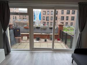 a room with a sliding glass door looking out at a courtyard at Spacious Glasgow Group Stay in Glasgow