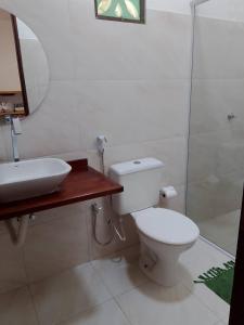 a bathroom with a toilet and a sink and a shower at Casa Bosque Guajiru in Trairi