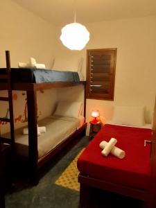 a room with two bunk beds and a red stool at Casa Bosque Guajiru in Trairi
