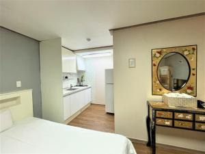 a bedroom with a bed and a mirror on the wall at HY Choi Hostel in Seogwipo