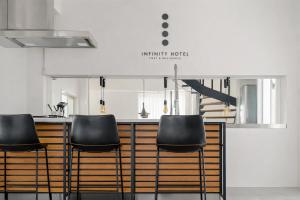 a kitchen with black chairs and a counter at INFINITY HOTEL -Higawa- in Naha +62 photos