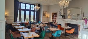a restaurant with tables and chairs and a fireplace at Stanhill Court Hotel, a member of Radisson Individuals in Horley