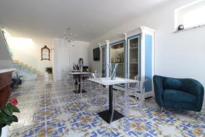 ein Wohnzimmer mit einem Tisch und einem blauen Stuhl in der Unterkunft Paomà in Agropoli