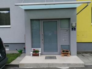 a front door of a house with two benches and flowers at Ferienwohnung Veitsch in Niederaigen