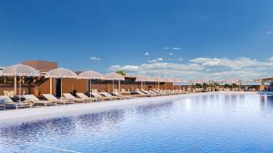 a swimming pool with lounge chairs and umbrellas at The Lince Ecorkhotel Évora in Évora