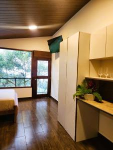a room with a bed and a kitchen with a table at Suite relax entre naturaleza y piscina en Tulipe in El Porvenir