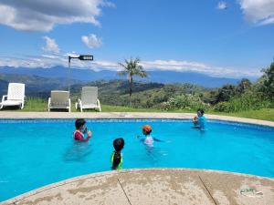 a group of children playing in a swimming pool at Suite relax entre naturaleza y piscina en Tulipe in El Porvenir