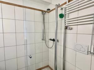 a shower in a bathroom with white tiles at 3BR-Innenstadt-WIFI-Parking in Bremerhaven +37 photos