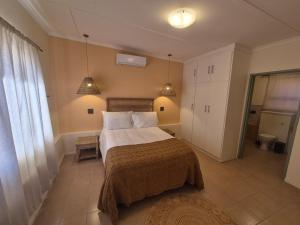 a bedroom with a bed and two pendant lights at Vida Lenta in Springbok