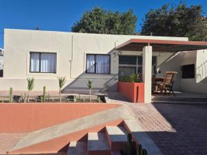 a white house with a bench in front of it at Vida Lenta in Springbok