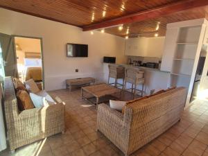 a living room with two couches and a kitchen at Vida Lenta in Springbok