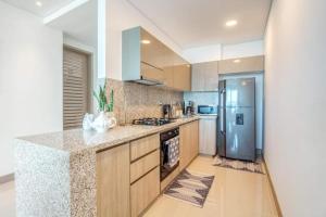 a kitchen with a refrigerator and a counter top at Beachfront 2BR Luxury Living Walk Everywhere in Cartagena de Indias