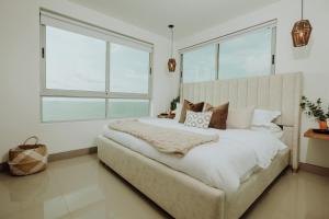 a bedroom with a large bed with a large window at Beachfront 2BR Luxury Living Walk Everywhere in Cartagena de Indias +16 photos