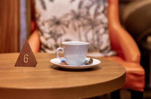 a cup of coffee on a table with a napkin at Hotel M'Rode in Lomé